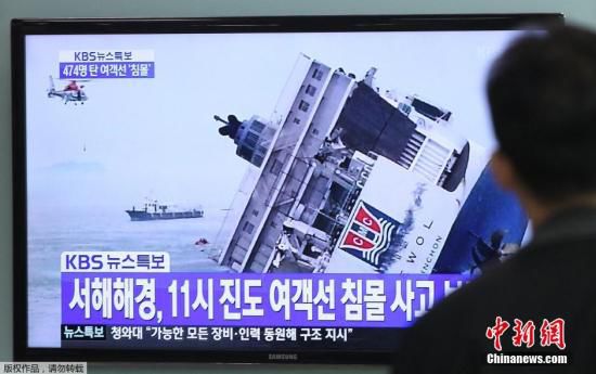 图为当地时间2014年4月16日，韩国民众关注客轮沉没的电视新闻报道。