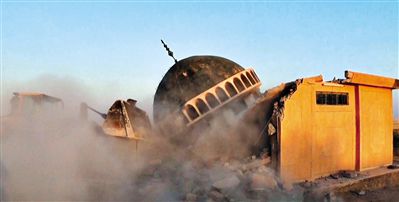 ISIS武装人员驾驶推土机推倒一座清真寺的墙体。