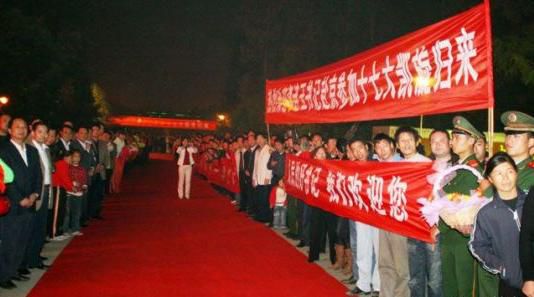 “夹道欢迎”中不少人打出横幅，路上被铺上了红毯。