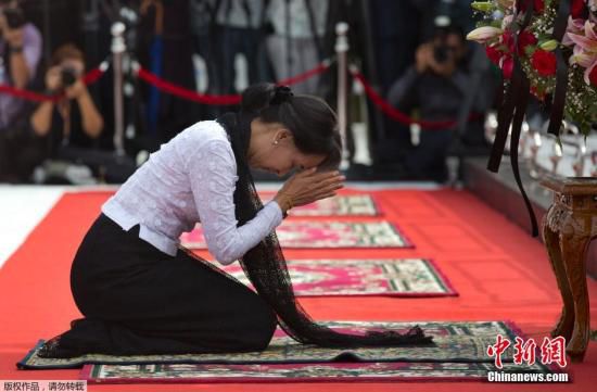 资料图：当地时间2014年7月19日，缅甸仰光，缅甸反对派领导人昂山素季向父亲昂山将军的陵墓叩拜。