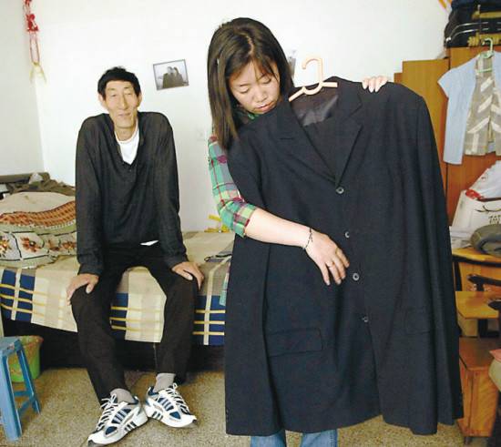 图：出门前妻子为鲍喜顺整理衣服。