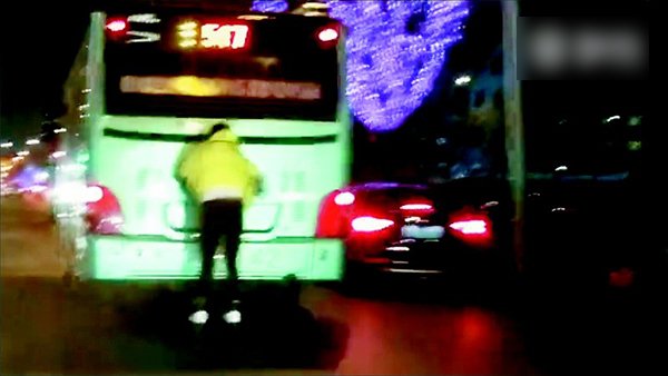 网友拍到手扒公交车玩轮滑的男子。视频截图