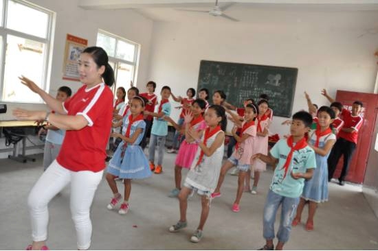 志愿者指导孩子们练习健美操，孩子们感到新鲜又有趣。