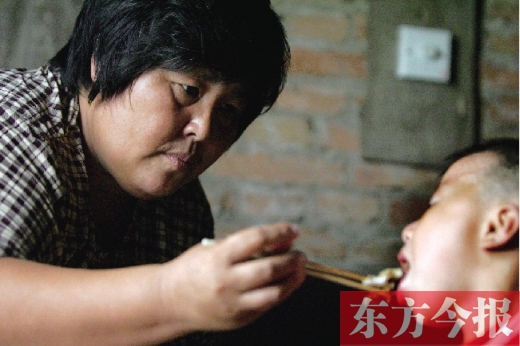 2006年7月，“爱心妈妈”袁厉害在照顾收养的弃儿 东方今报记者 刘栋杰 摄（资料图片）