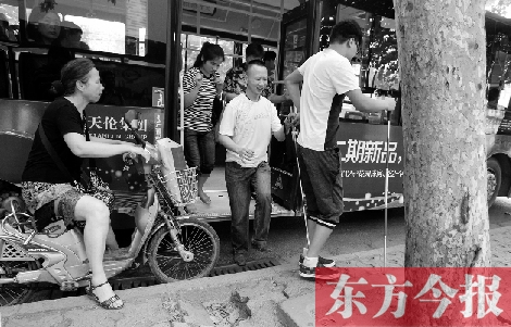 每到下车时，宋鹏（右一）和胡兴开（右二）都很艰难，好在周围的市民都挺照顾的