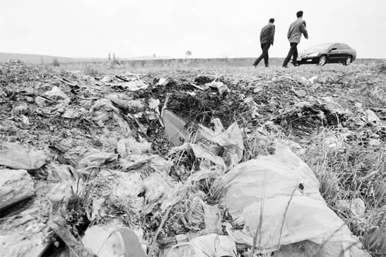 在宁夏西吉县将台乡一处村庄内，路边堆放着当地农民焚烧后的废旧塑料农膜，土壤污染不容忽视 新华社发