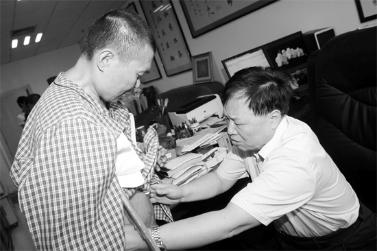昨天，陕西西安第四军医大学唐都医院骨肿瘤专家范清宇教授（右）在为李刚做检查