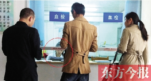 昨日，郑州市二七区疾控中心办证大厅，血检窗口内一名女工作人员，边接受办证者咨询边看报纸