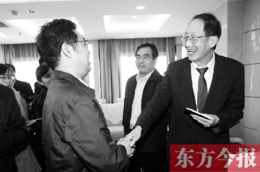 崔琦先生握手东方今报记者靳晖，感谢他把照片珍藏了15年