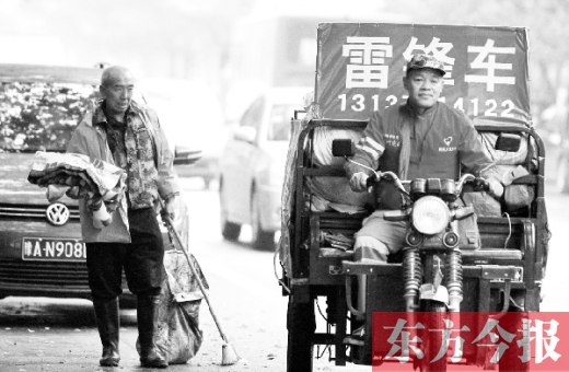郑州市商城路，一名环卫工怀抱着刚刚收到的毯子，目送“雷锋哥”孙德坤离开