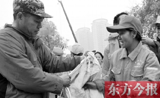 11月9日，“雷锋哥”孙德坤（左一）将大家捐赠的棉衣捐给了郑州市金水区一线的环卫工师傅