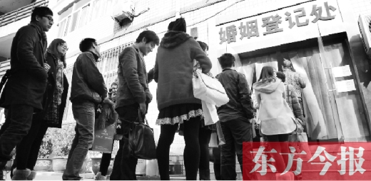 昨日，郑州市中原区婚姻登记处等待“领证”的情侣们将队伍延伸至办事大厅大门外