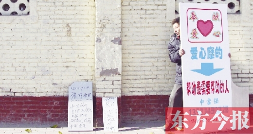 12月9日，郑州市京广路。装修师傅老申摆出自己“奉献爱心”的牌子