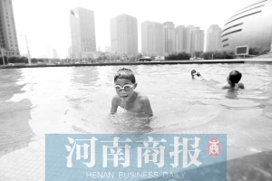 郑州天热难耐，小朋友忍不住在水池里游泳 赵卓/摄