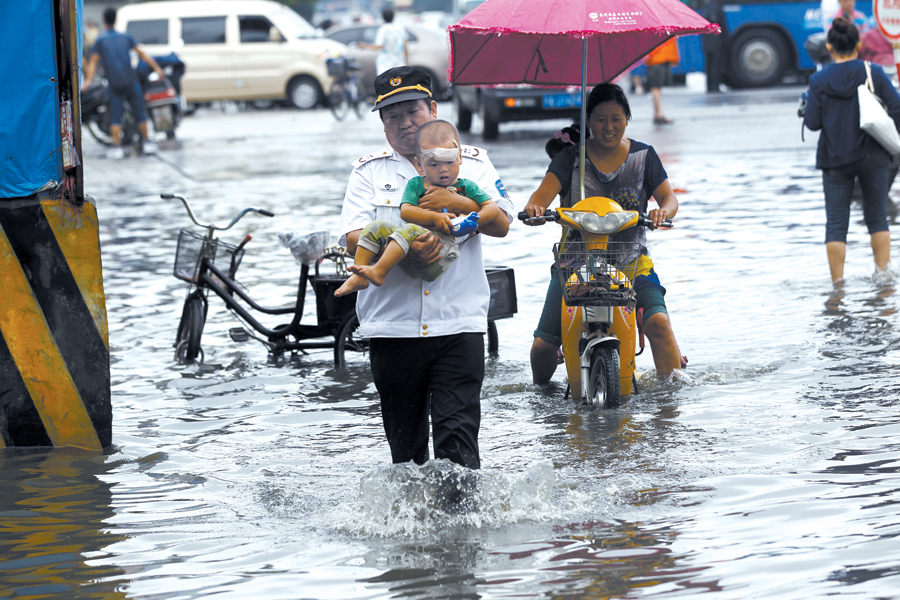 昨天一场大雨，郑州市区个别路段积水成河。俩巡防队员蹚水帮行人过马路，市民称赞。图为郑州桐柏路与建设路