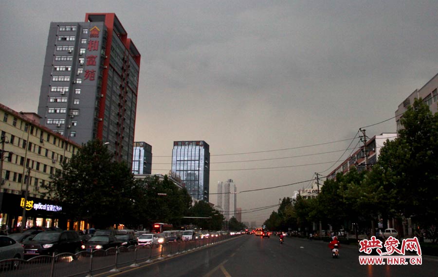 暴雨之前天空黑的像晚上，路上的汽车都打开了车灯