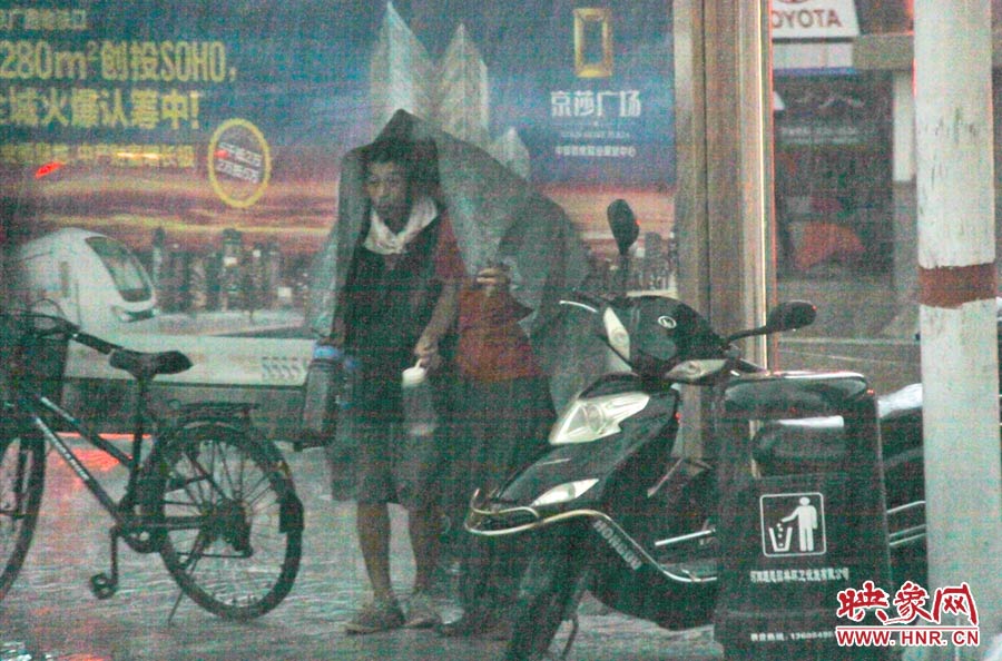 在路边的公交车站下躲雨