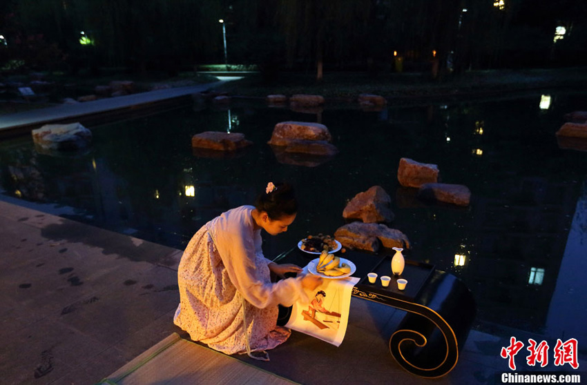 8月11日晚，身着汉服的姑娘们在举行拜织女仪式。中新社发 泱波 摄