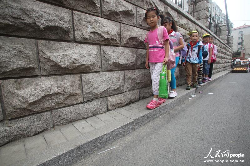 2013年09月11日，济南运署街上，小学生走史上“最窄人行道”上学。图片来源：CFP