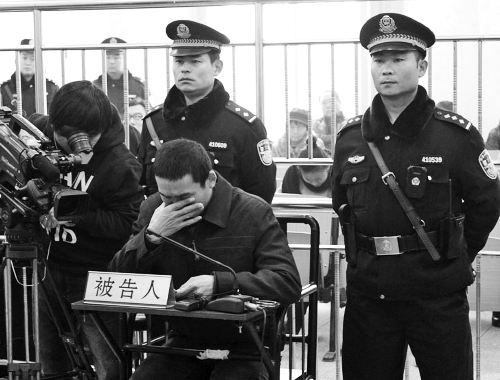 庭审中,29岁的李军低着头。