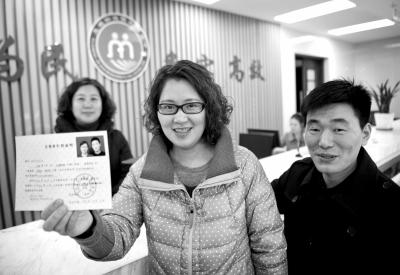 2014年1月27日，浙江台州，王传远、陈芳芳夫妻俩举起再生育证向人们展示。图/东方IC