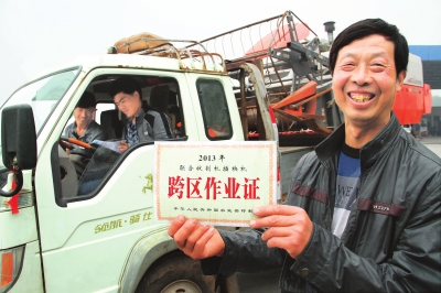 　5月6日，县嘉应观乡东营村农机手荆占通在展示他的跨区作业证。当日，该县60多台履带式收割机奔赴四川