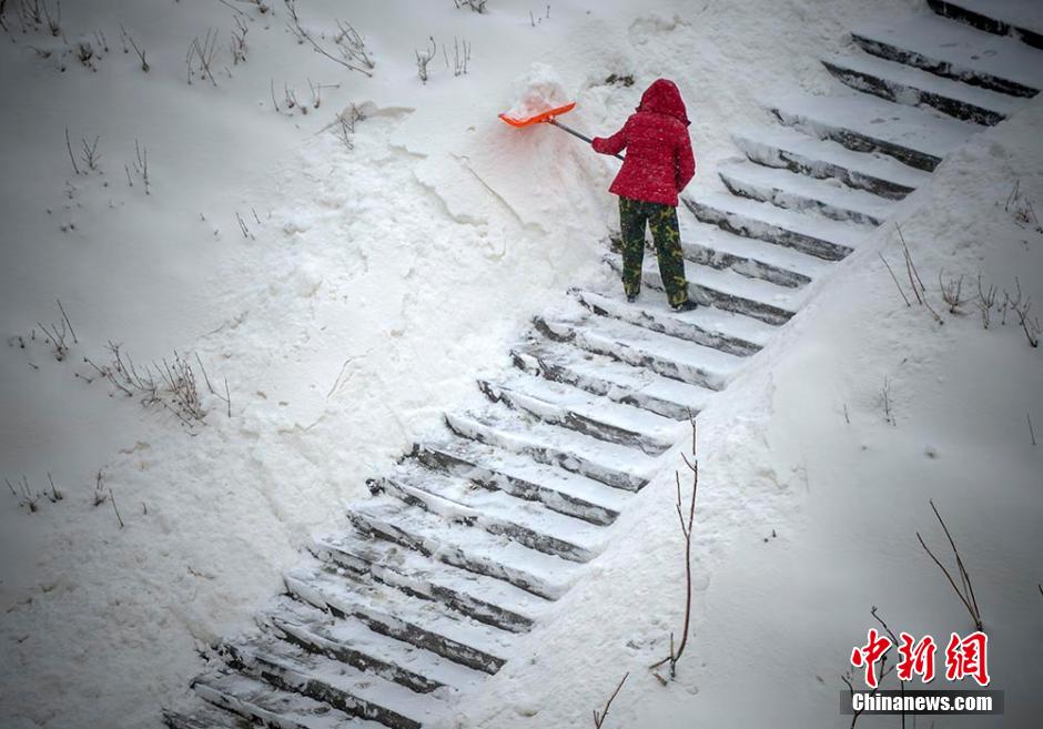 图为市民清理道路积雪。 刘新 摄