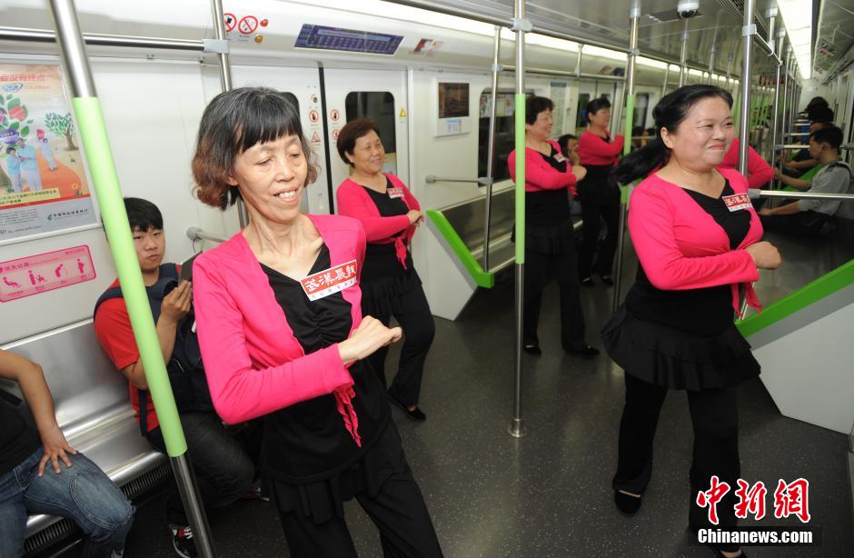 5月10日，武汉地铁2号线内，一群大妈身着舞裙，随着音乐节拍大秀舞姿，引来乘客们阵阵掌声。