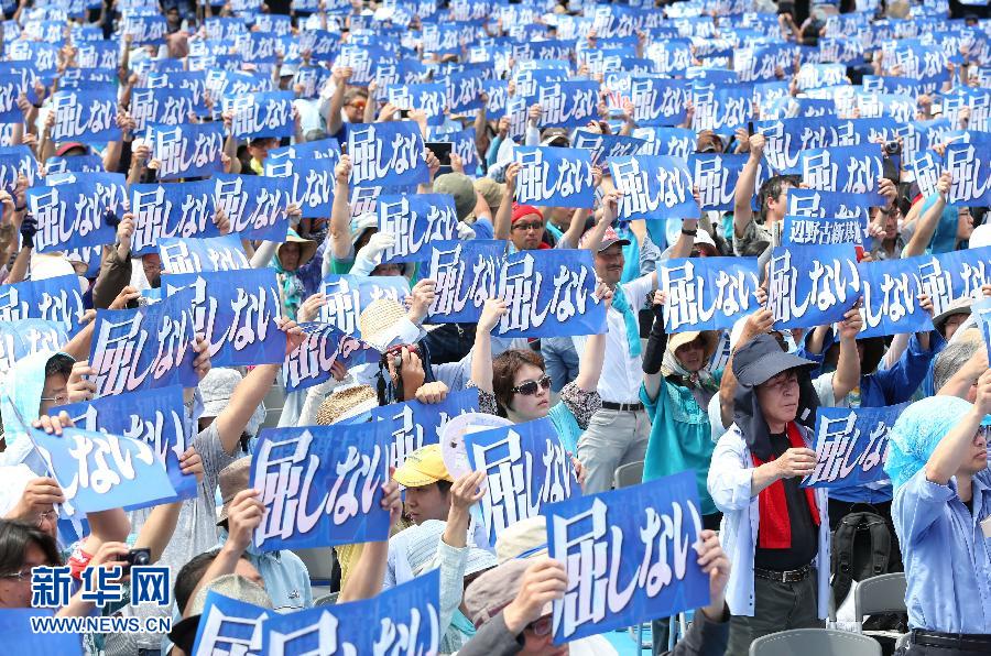 5月17日，在日本冲绳县那霸市，民众在集会上手举标语抗议。