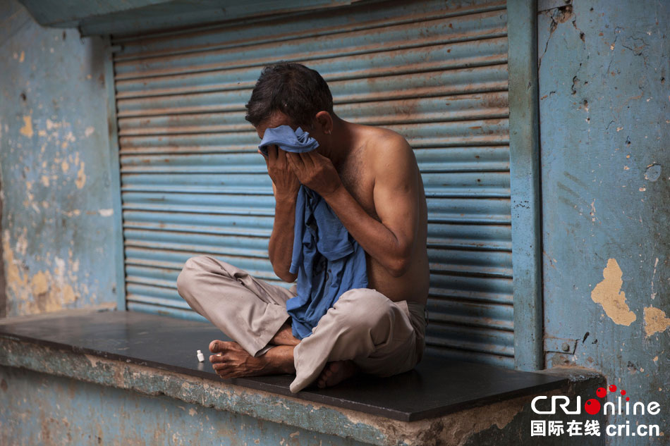 印度新德里，一名男子擦汗。　