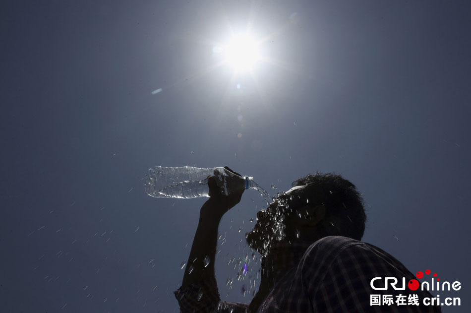 印度海得拉巴，一名男子将水浇在脸上。