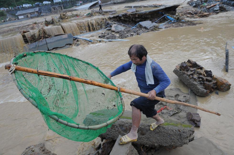 贵州雷山遭暴雨袭击 村民在洪水中淡定捞鱼