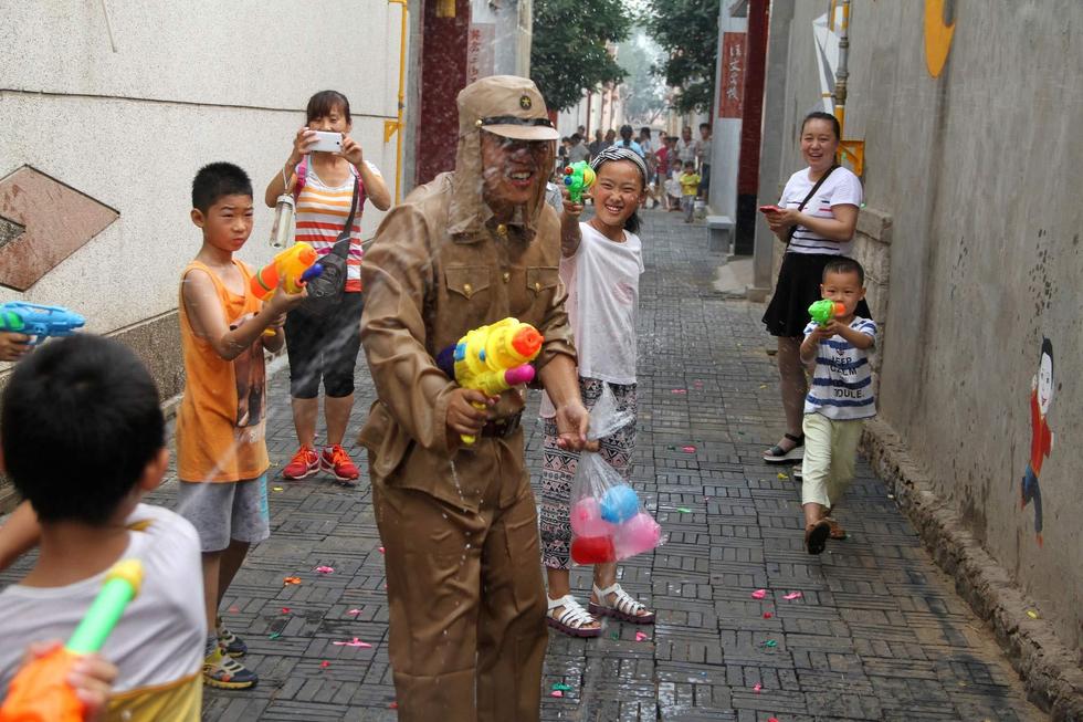 孩子们扮成八路军手持水枪打鬼子。