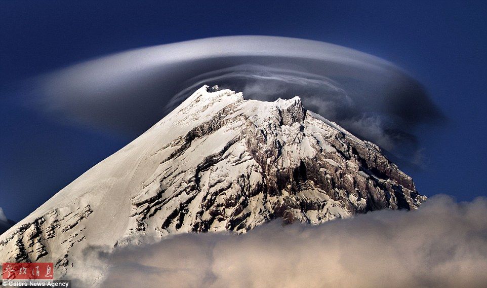 火山上笼罩着类似于外星飞碟形状的云彩，场景犹如科幻大片。