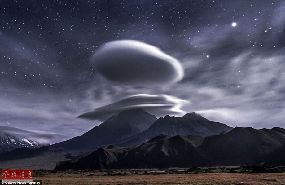 火山上笼罩着类似于外星飞碟形状的云彩，场景犹如科幻大片。