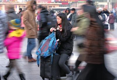 春运首日，北京站客流量明显增多，一名女孩在人流中等待进站。