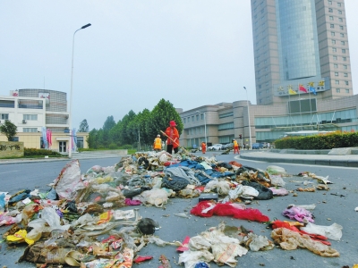 环卫工人清扫路上被抛撒的生活垃圾