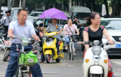 街头打伞的电动车