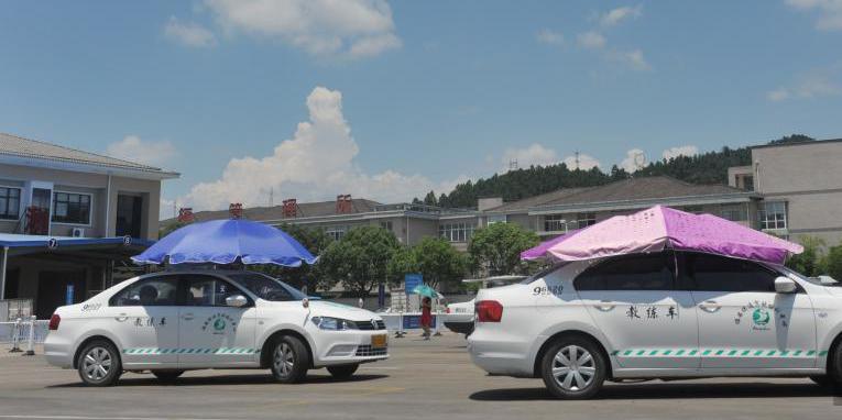 杭州一驾校现遮阳新招 教练车车顶撑伞