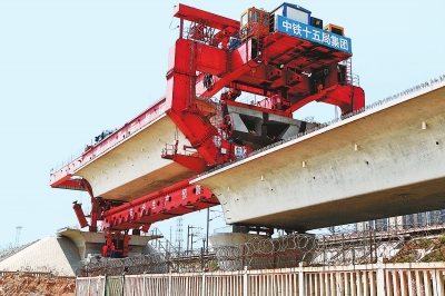 建设者们操纵巨型起重机在吊放桥墩。记者邓放摄
