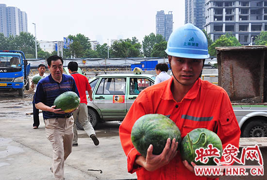 爱心的哥的姐将买来的西瓜送给工地上的工人
