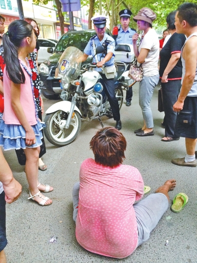 在郑州优胜南路东三街交叉口向东100米处，一名短发中年女子平躺在路南快车道上，身旁还有一只掉落的拖鞋