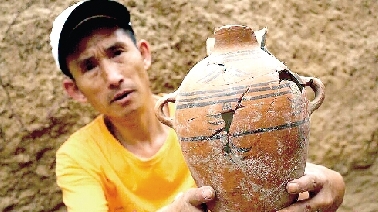 　　考古工作人员展示出土的仰韶文化时期代表性彩陶。