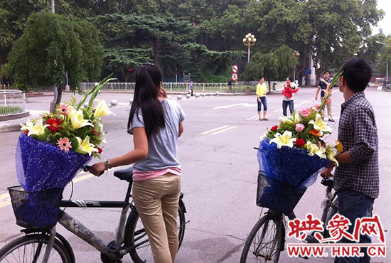 在郑州大学南校区，有不少学生三五成群，手捧鲜花。