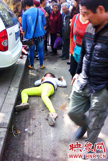 一个小女孩受伤躺在地上。
