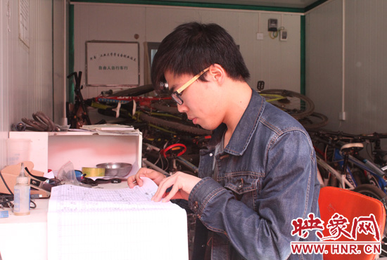 在河南工业大学东门外的一个简易板房里，梁鹏正在值班。