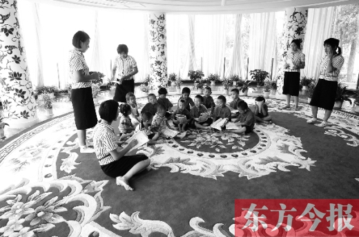 郑州一幼儿园里的孩子在老师的带领下读《论语》。