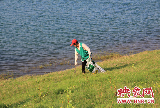 2014年7月份，丹江口岸边护水队队员正在清理垃圾。