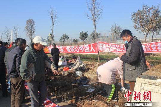 图为百余名爱狗人士把老李的货车拦截，数十人正在从货车上卸下装满狗的铁笼。　马义恒　摄