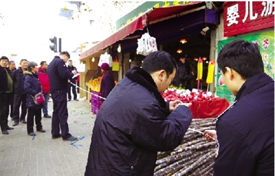 中原区执法人员对水果店的占道经营行为取证